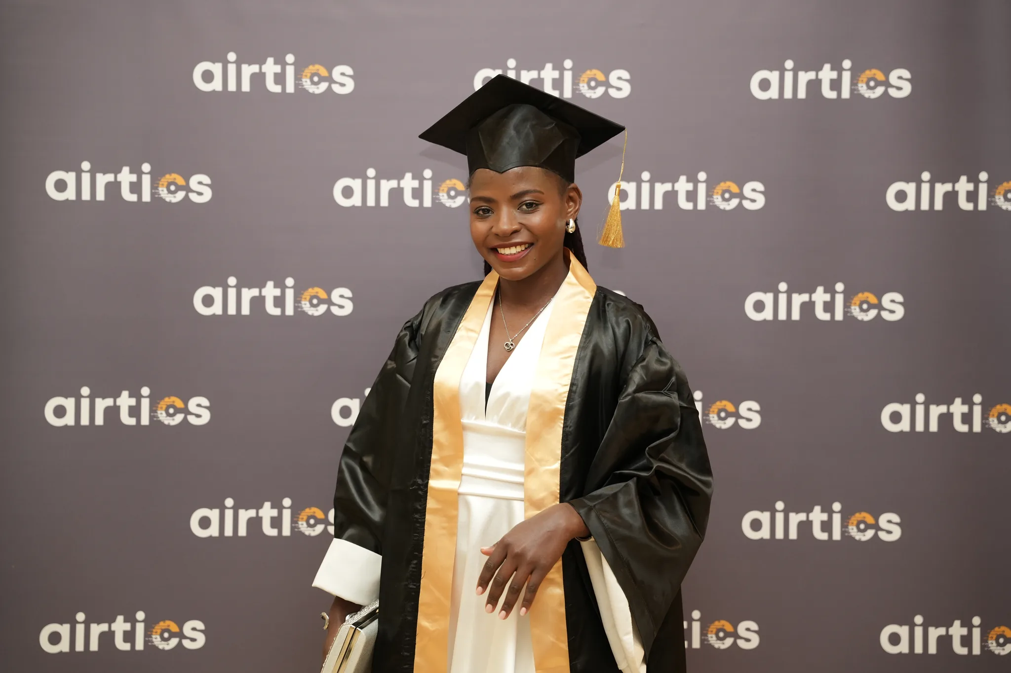 Airtics Graduation 2026: graduate in cap and gown at the Airtics photo backdrop