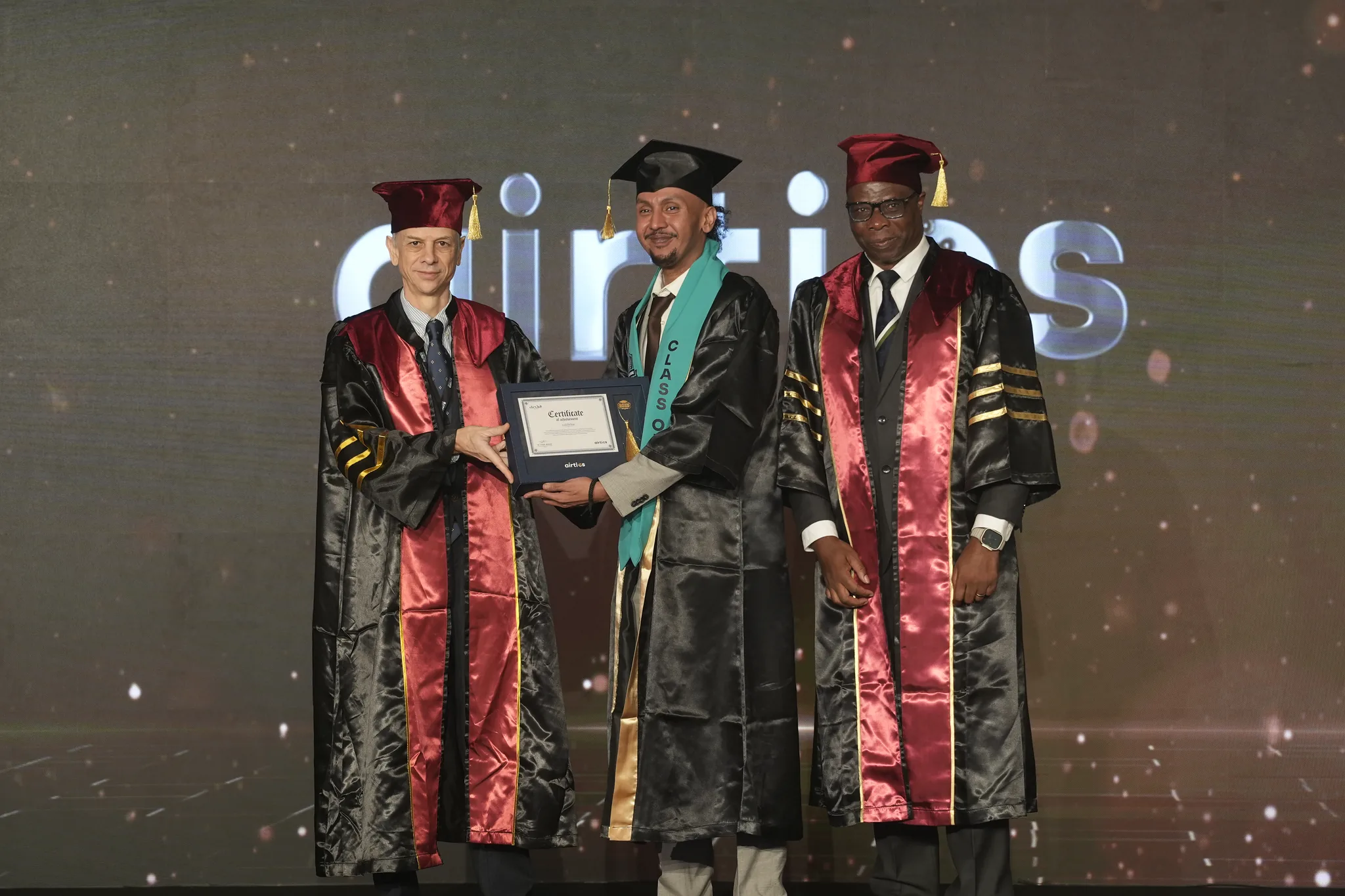 Airtics Graduation 2026: graduate receiving their certificate on stage from the Airtics academic panel
