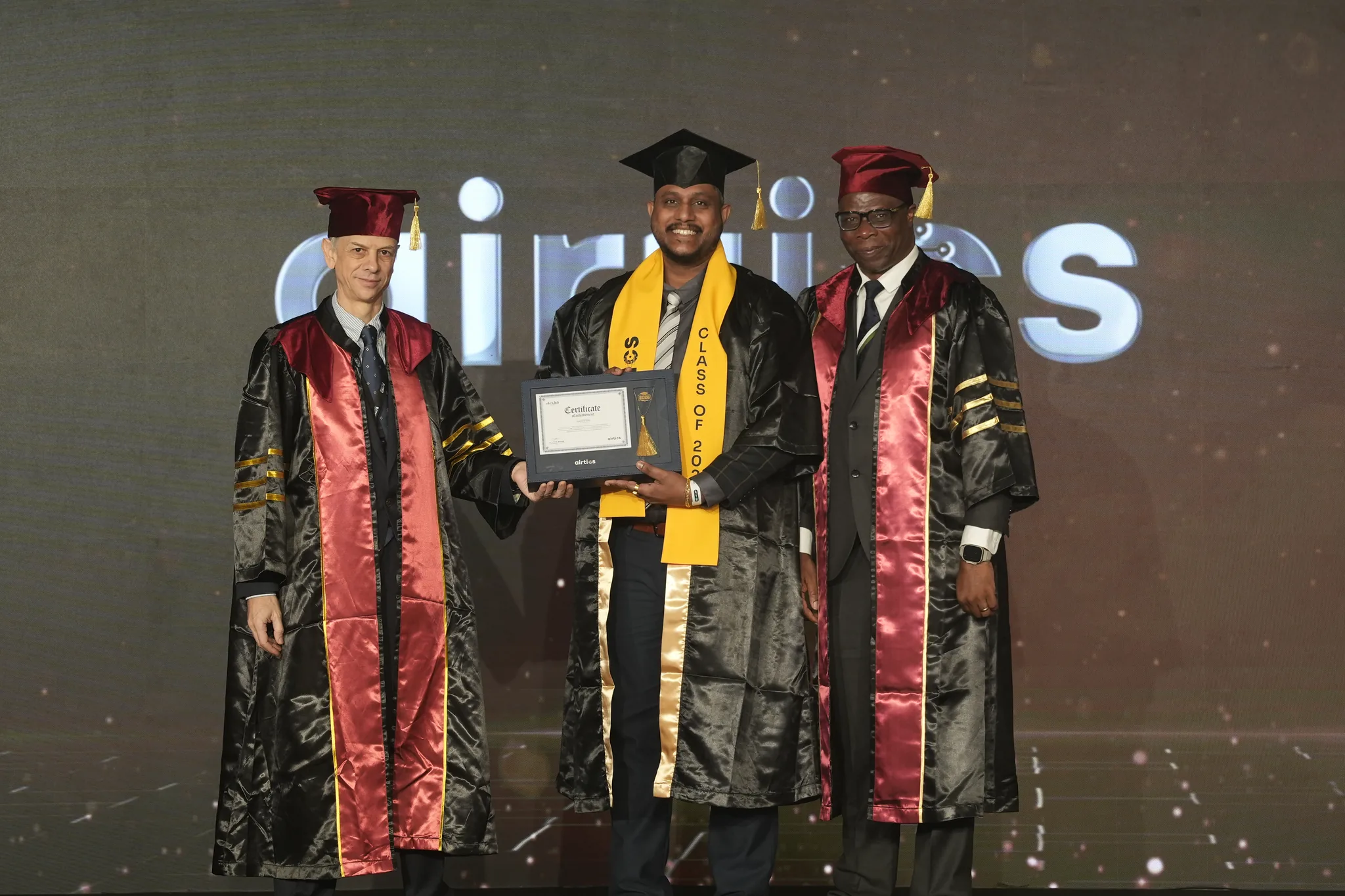 Airtics Graduation 2026: graduate receiving their certificate on stage from the Airtics academic panel