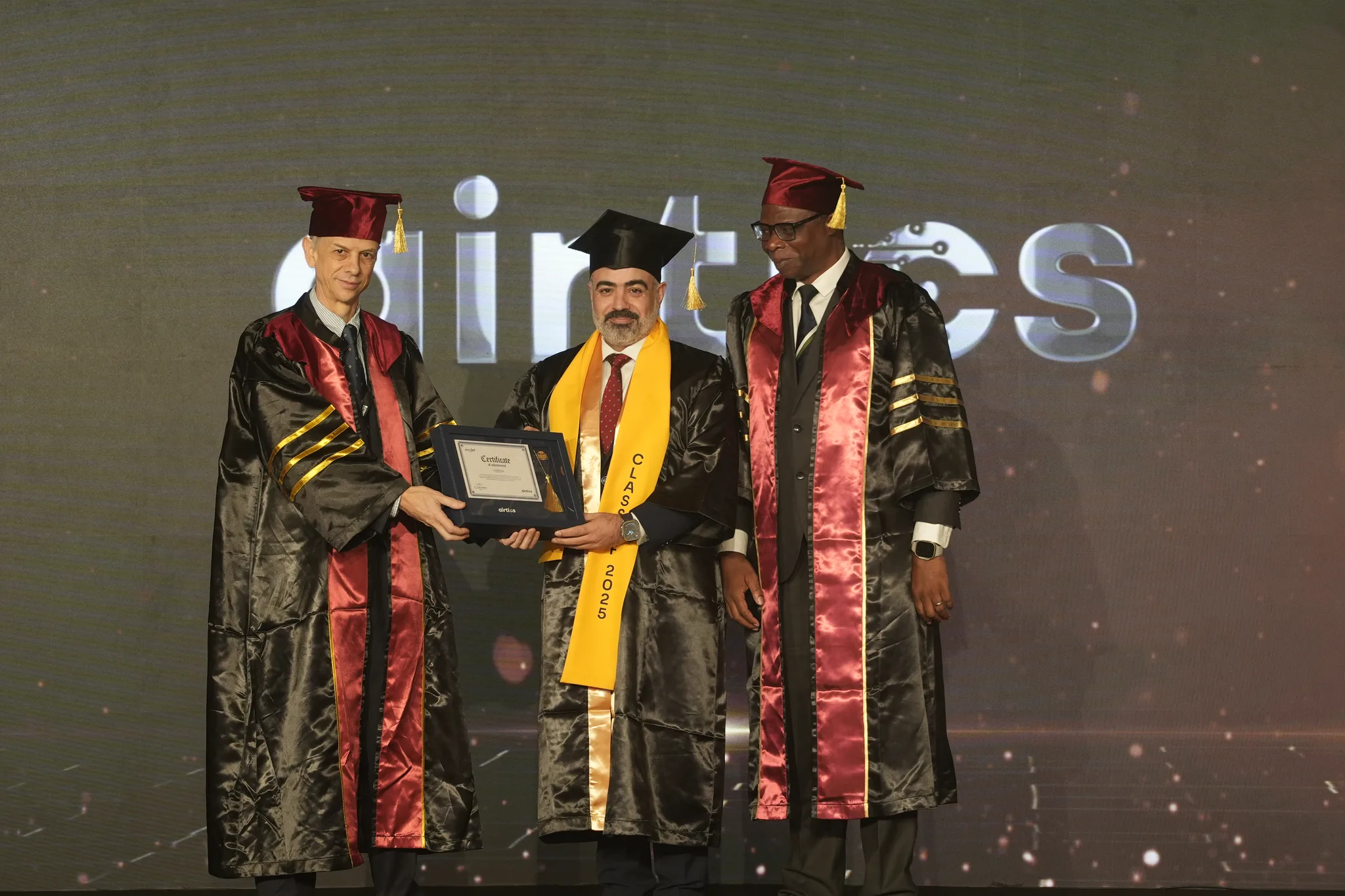 Airtics Graduation 2026: graduate receiving their certificate on stage from the Airtics academic panel