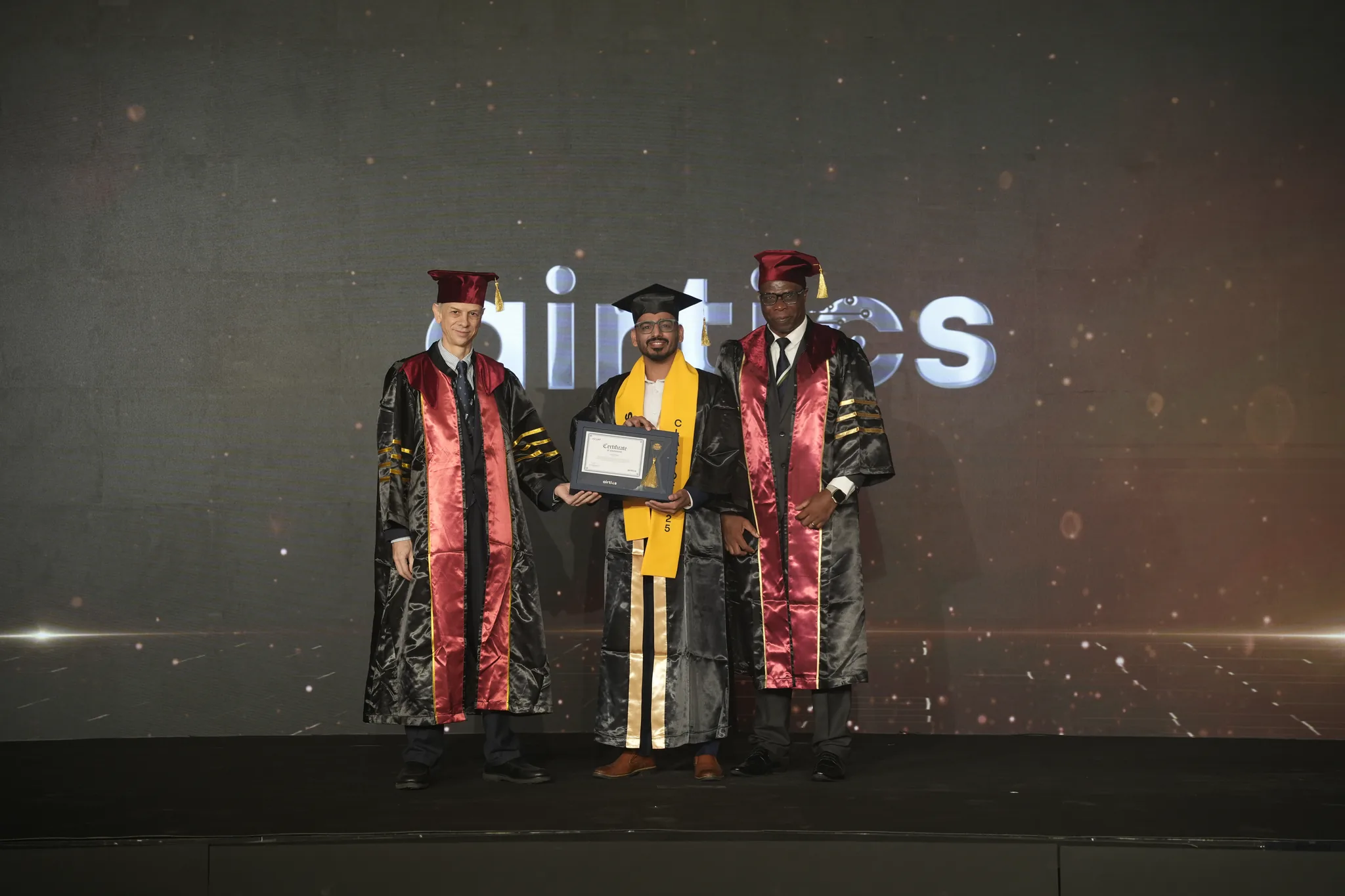 Airtics Graduation 2026: graduate receiving their certificate on stage from the Airtics academic panel
