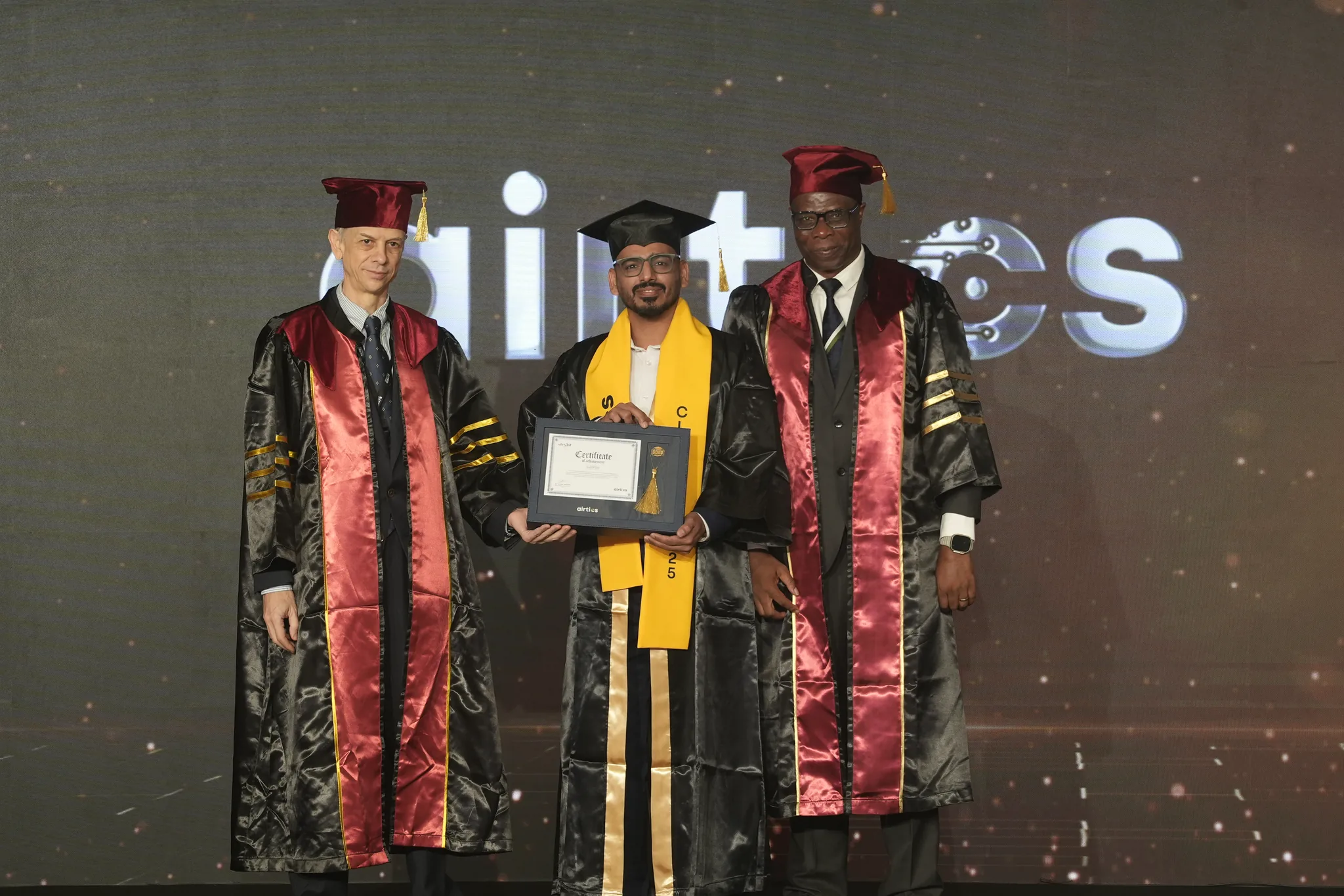 Airtics Graduation 2026: graduate receiving their certificate on stage from the Airtics academic panel