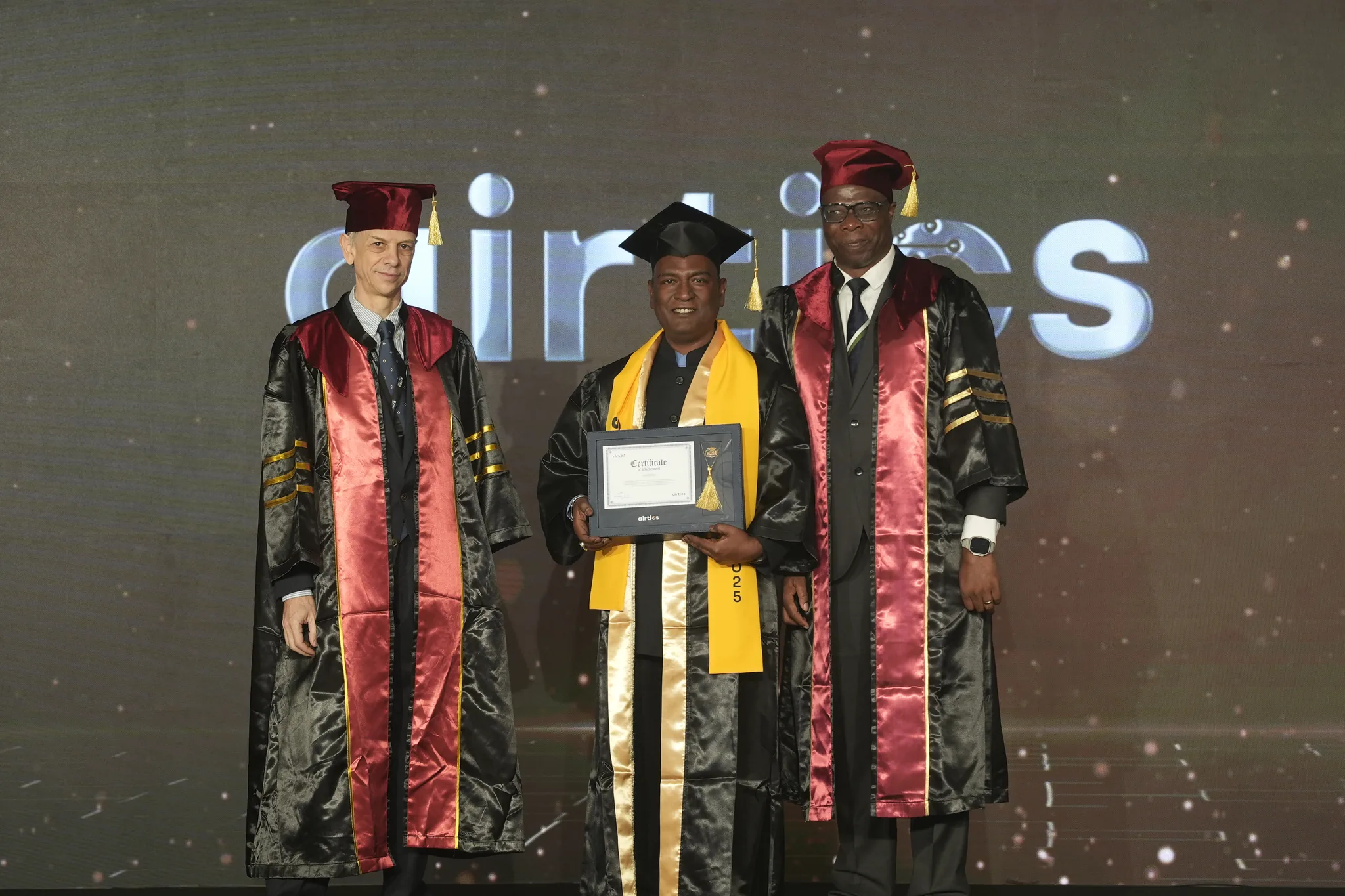 Airtics Graduation 2026: graduate receiving their certificate on stage from the Airtics academic panel