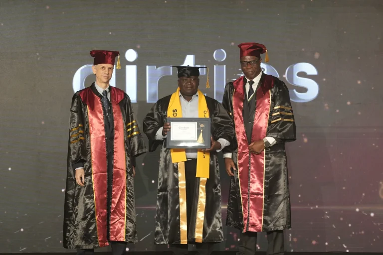 A graduate receives his award on stage with faculty