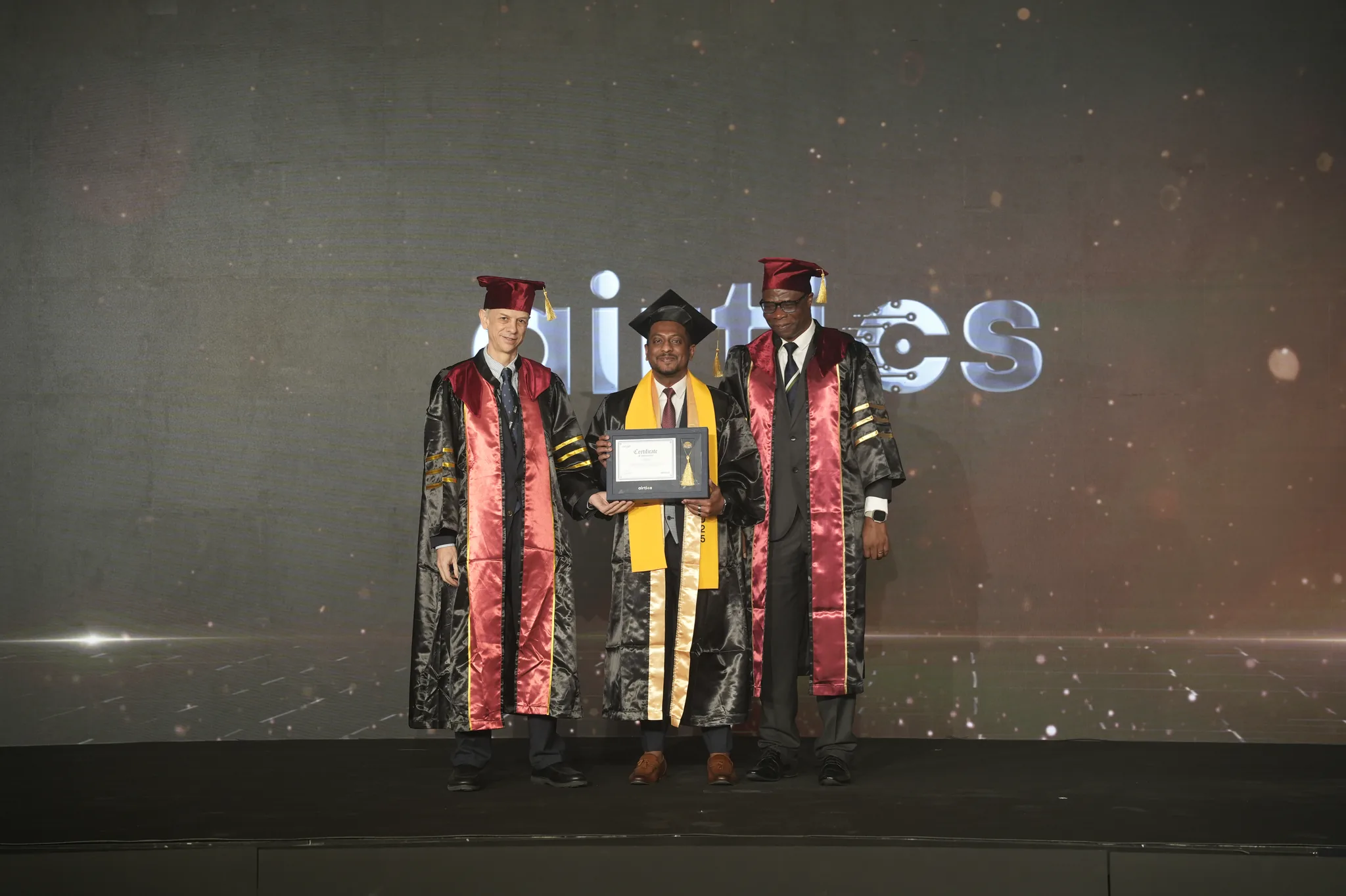 Airtics Graduation 2026: graduate receiving their certificate on stage from the Airtics academic panel