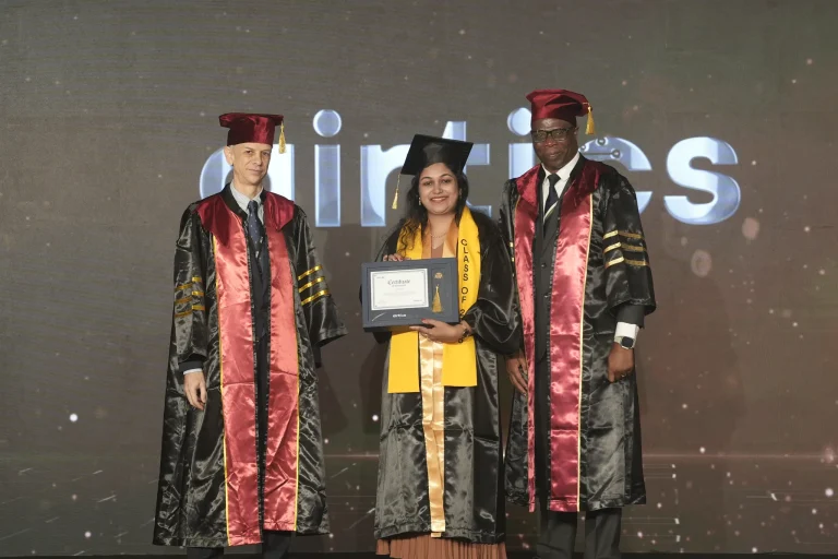A graduate receives her award on stage with faculty