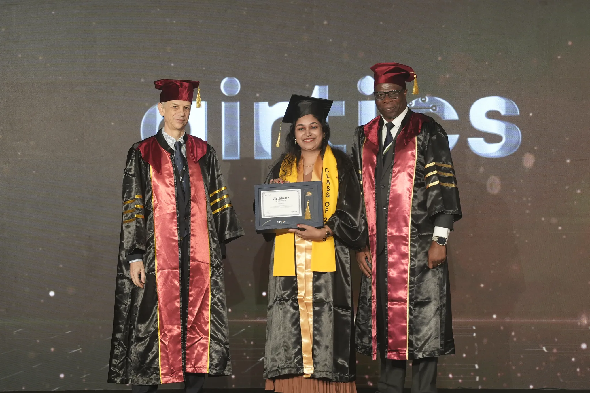 Airtics Graduation 2026: graduate receiving their certificate on stage from the Airtics academic panel