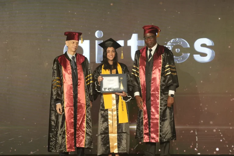 A graduate receives her award on stage with faculty