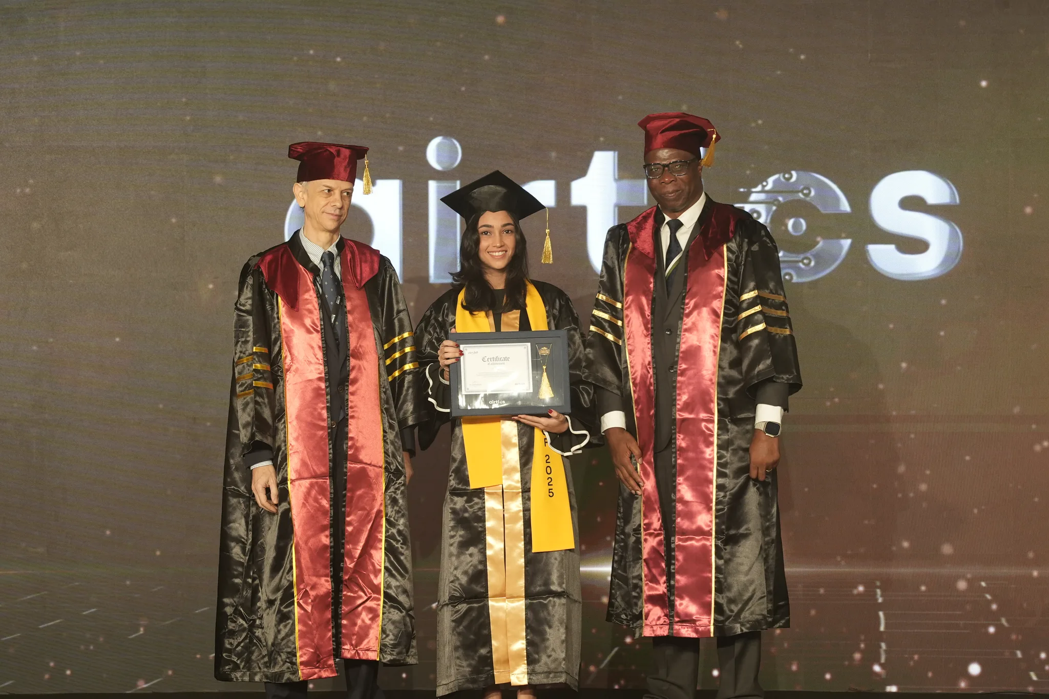Airtics Graduation 2026: graduate receiving their certificate on stage from the Airtics academic panel