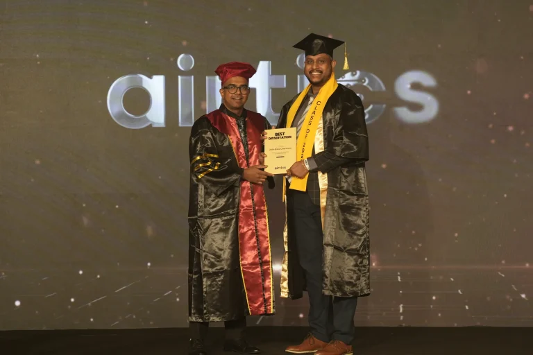 A graduate receives his award on stage with faculty