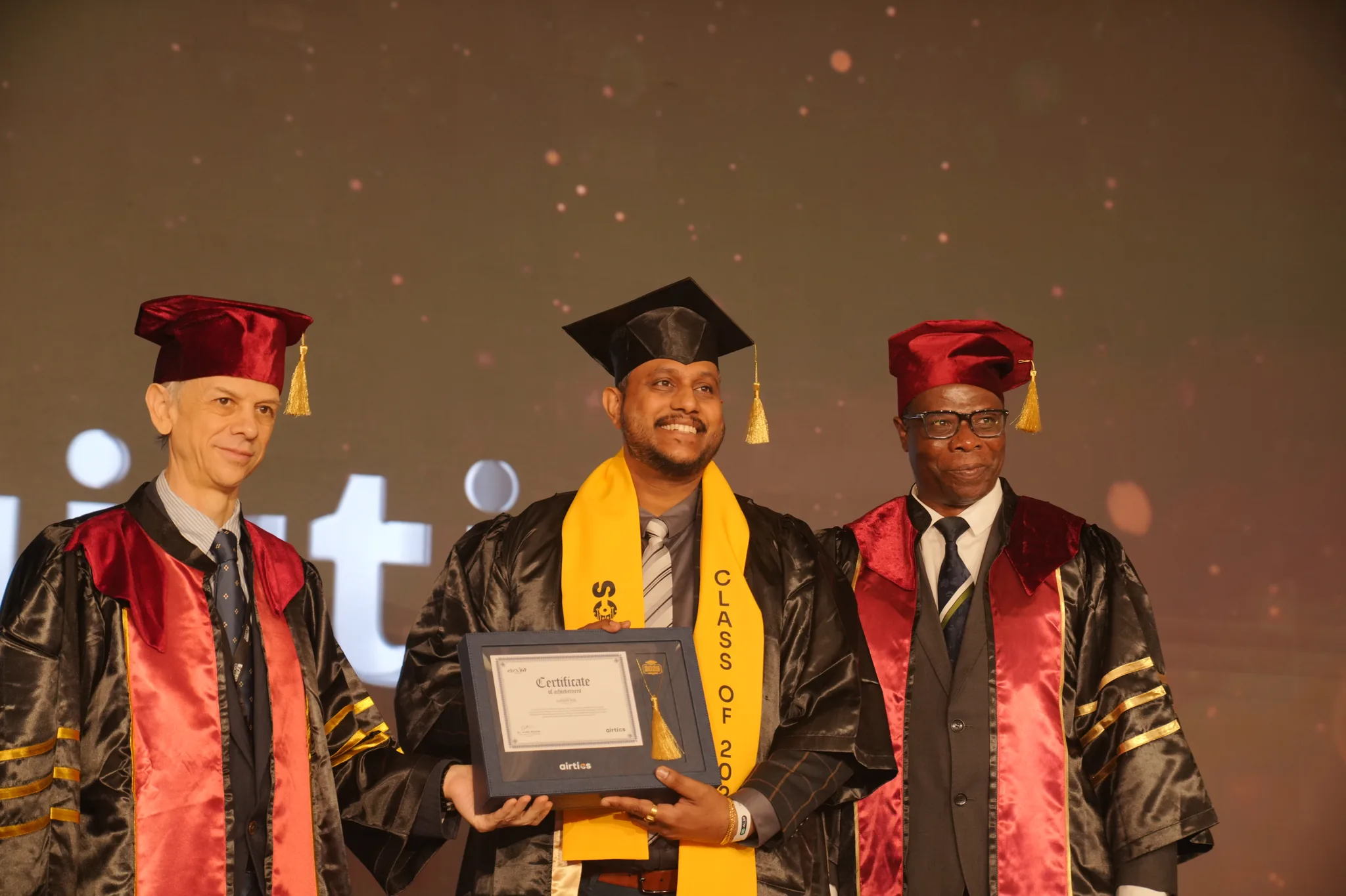 Airtics Graduation 2026: graduate receiving their certificate on stage from the Airtics academic panel